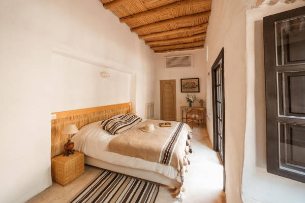 maison d’hôtes région marrakech - chambre avec lit double avec murs blancs et déco beige
