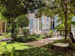 Jardin verdoyant et ombrage avec mobilier fer forgé