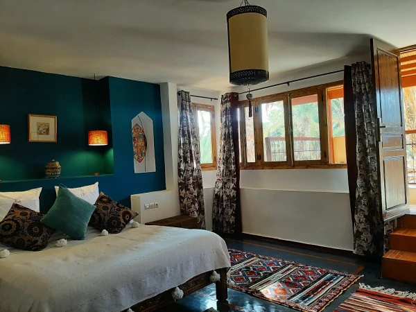 hotel agdz maroc - Suite double avec un mur bleu majorelle et un accès direct sur le jardin luxuriant