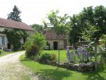 Photo du jardin fleuri où l'on peut également apercevoir les bâtiments en pierre