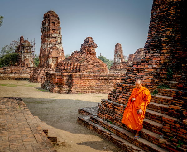 les temples de l'ancienne cité d'Ayutthaya avec un homme habillé en orange