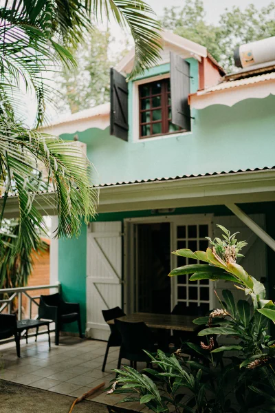 Maison duplex aux murs bleus avec une grande terrasse couverte