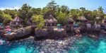 Photo prise depuis la mer, aux couleurs turquoises, des bungalows installés à flanc de rocher avec vue panoramique et terrasse et accès privé à la mer