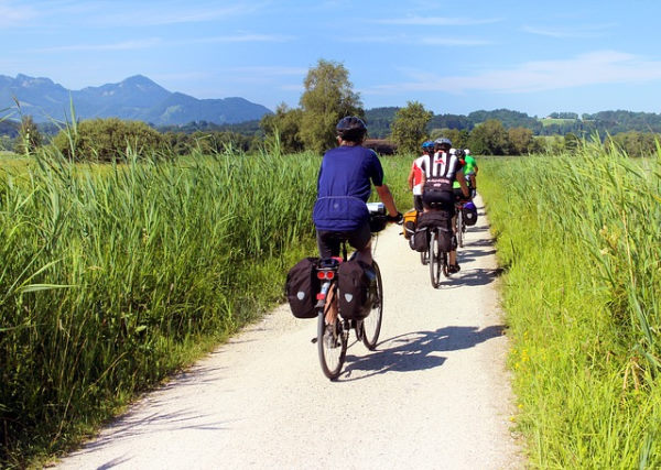 green tourism in france - group of people on bikes with panniers on a path surrounded by grass