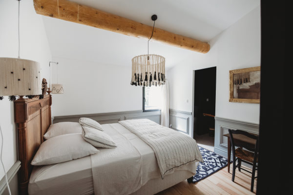 Chambre avec lit double en bois dans les couleurs blanc et gris