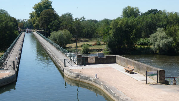 The canal bridge of Digoin with a barge at the end and underneath we see the Loire