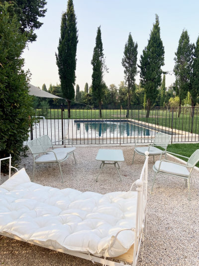 location de vacances avignon - Mobilier de chambre en fer forgé blanc avec des cousins blanc à côté de la piscine