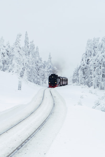 sleeper train trip in europe - train running on snowy rails in the middle of a snowy landscape and forest