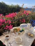 Table du petit dejeuner zero dechet entourée de bougainvilliers en fleur et avec vue sur la mer